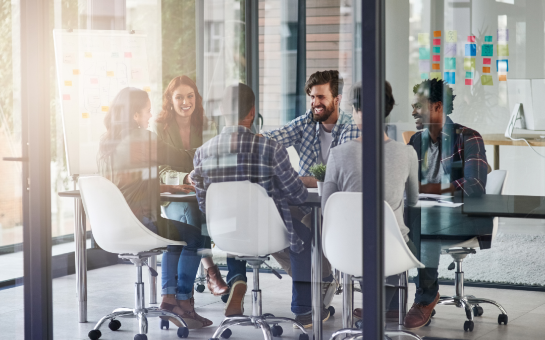Group of professionals collaborating at a table in a glass conference room.