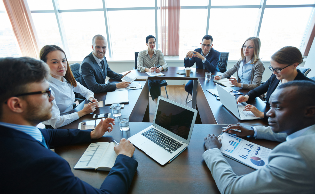 Group of professionals collaborating at a square table setup.
