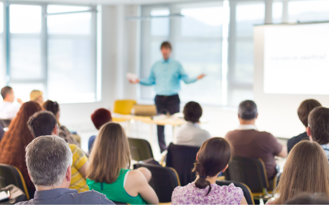 Man teaching a seminar in front of a whiteboard.