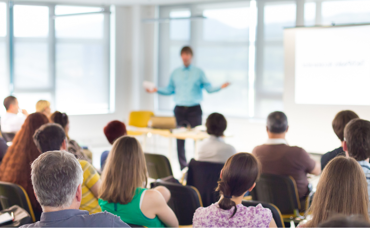 Man teaching a seminar in front of a whiteboard.