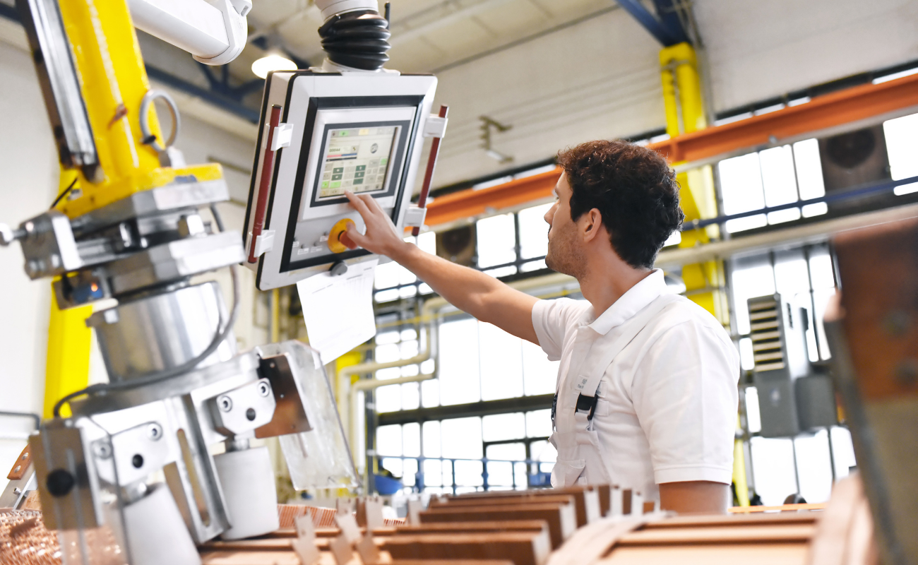 Man using computer display while operating machinery.