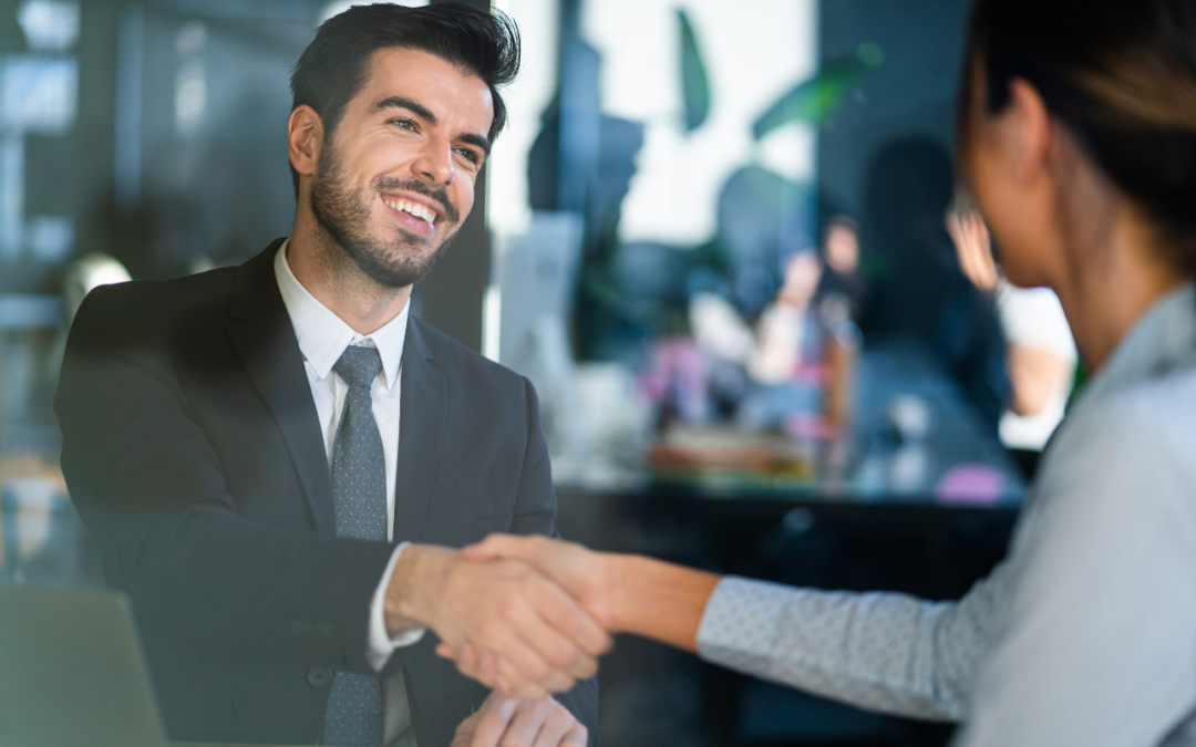 Man and woman shaking hands in a professional setting.