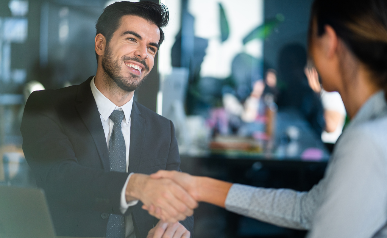 Man and woman shaking hands in a professional setting.